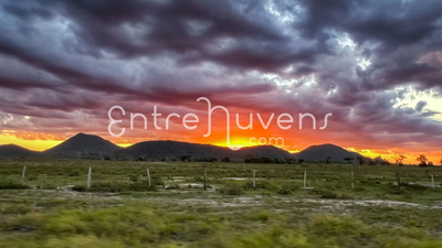 Por do sol dramático sobre montanhas verdes