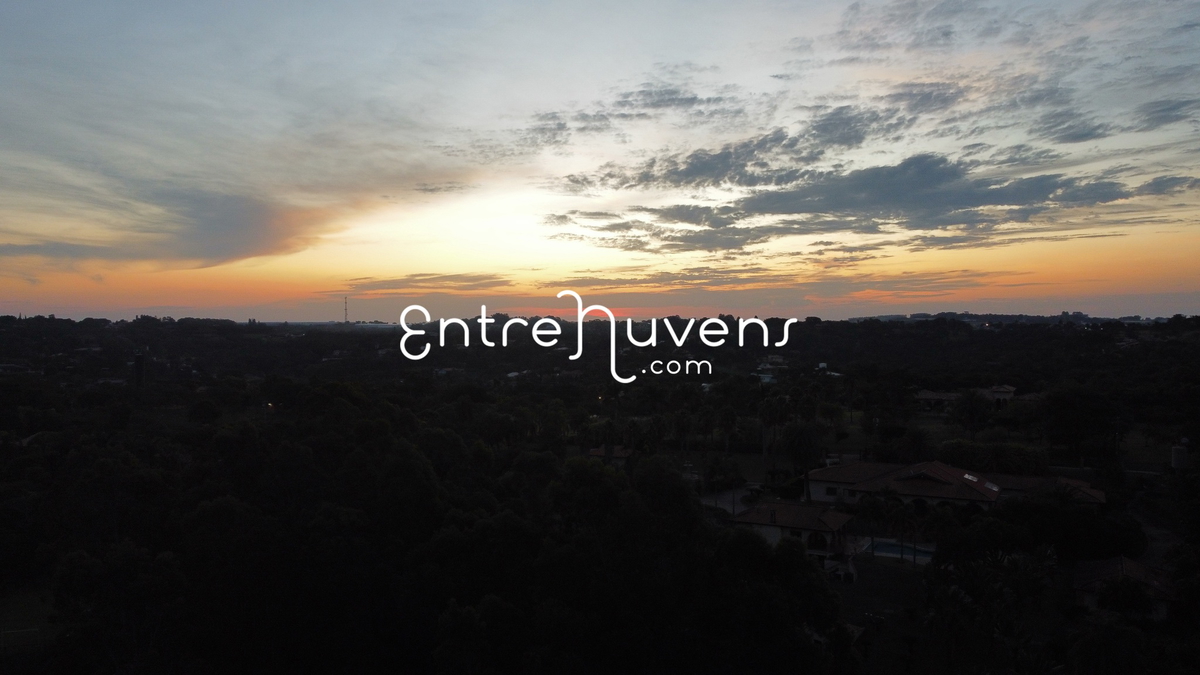 Por do sol sobre uma área de mata fechada.