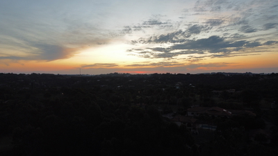 Por do sol sobre uma área de mata fechada.